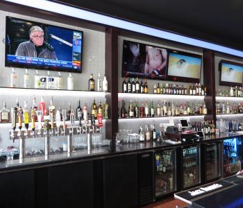 image of a bar inside a restaurant with 3 big flat screen tvs above the bar